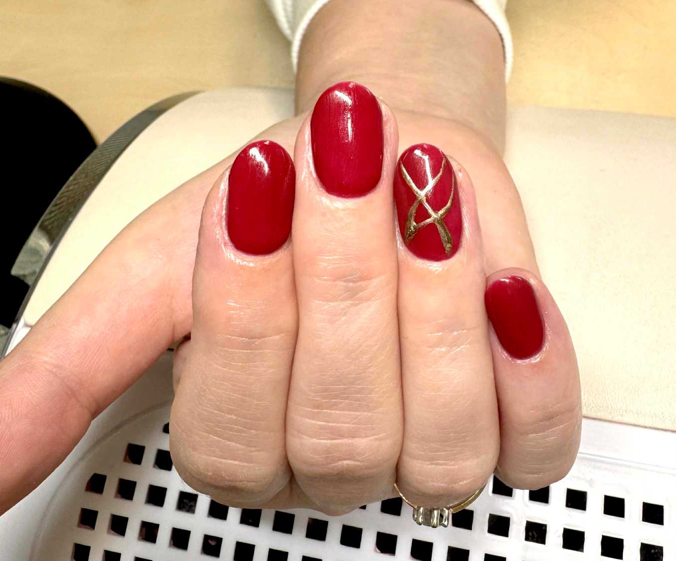 Cervene gelove nechty so zlatou liniou a nail artom